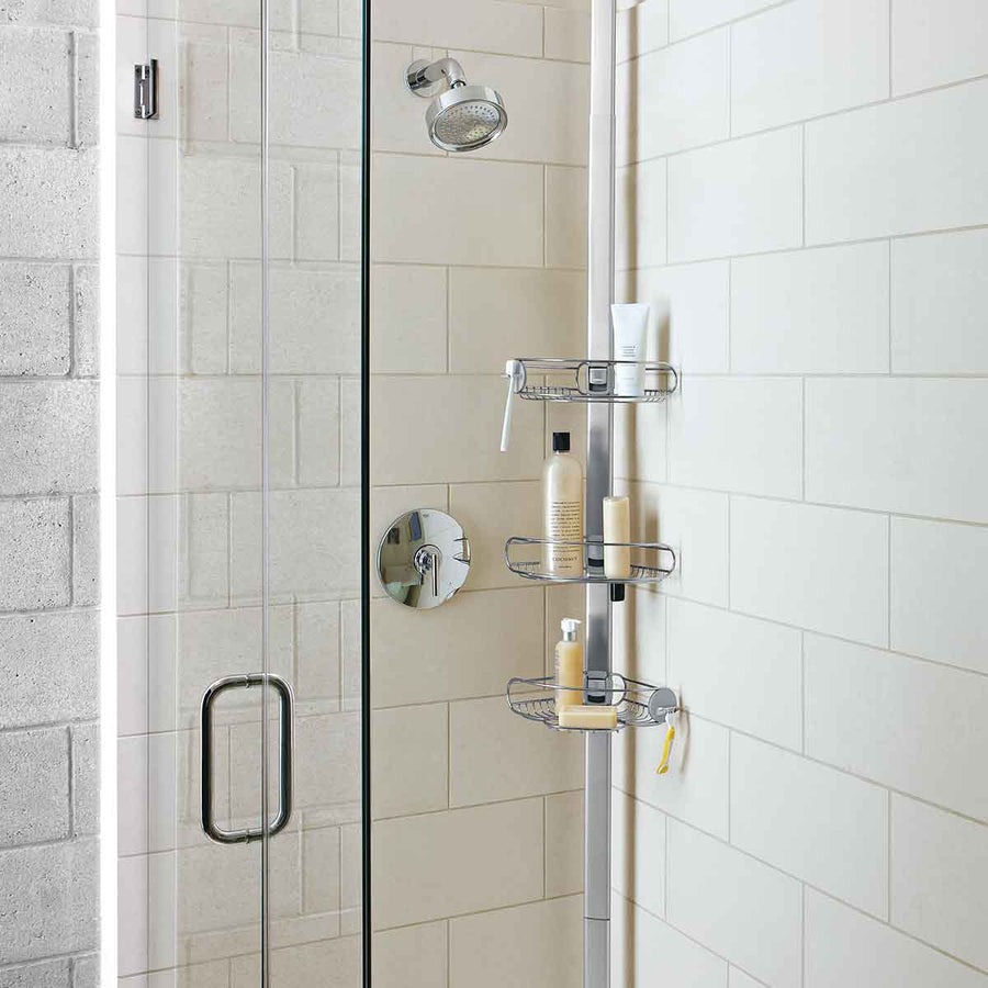 Angled view of Simplehuman Tension Shower Caddy, White/Polished Stainless Steel, adjustable shelves for maximizing vertical shower storage.