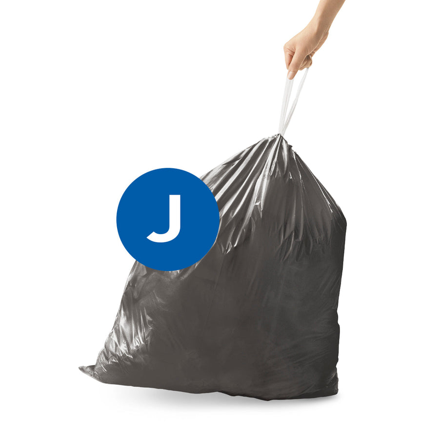 Angled view of Simplehuman Code J Odorsorb Liner, hand lifting sealed bag by drawstring closure.