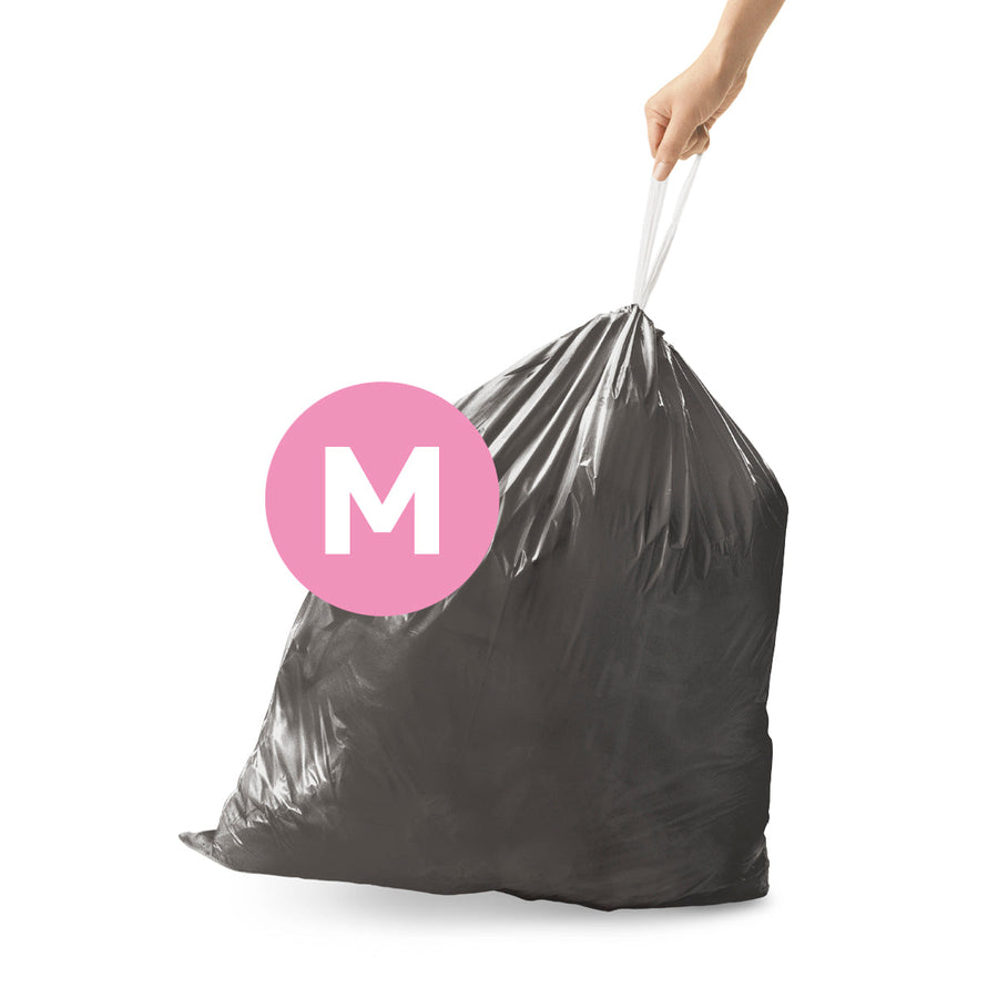 Simplehuman Code M Custom Fit Odorsorb liner full, being lifted by hand using the strong drawstring closure.