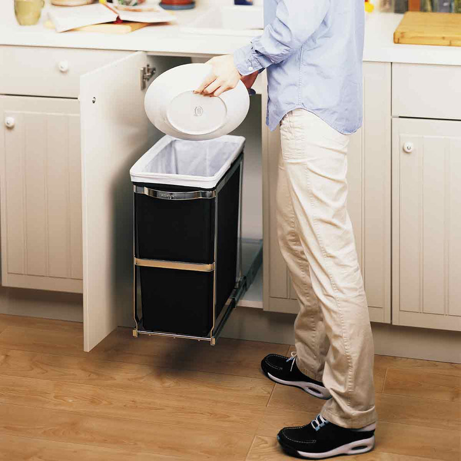 Lifestyle view of Simplehuman 30L Pull-Out Can, Polished Stainless Steel, extended for easy waste disposal.