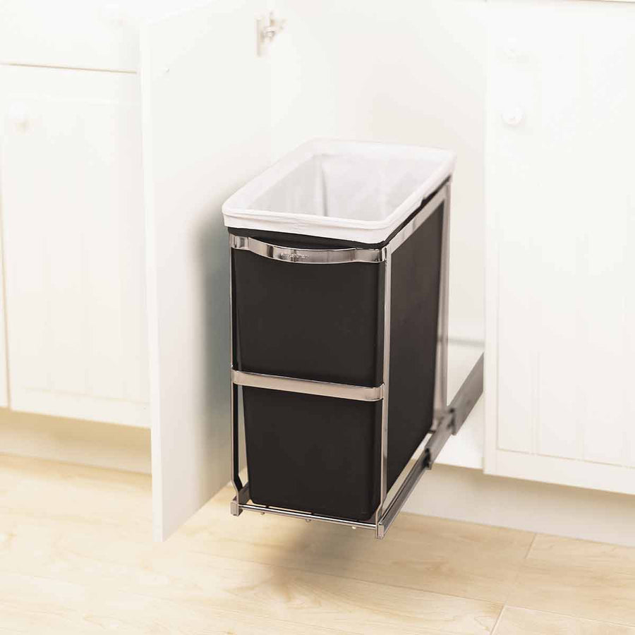 Detail view of Simplehuman 30L Pull-Out Can, Polished Stainless Steel frame holding black liner, fully extended under cabinet.