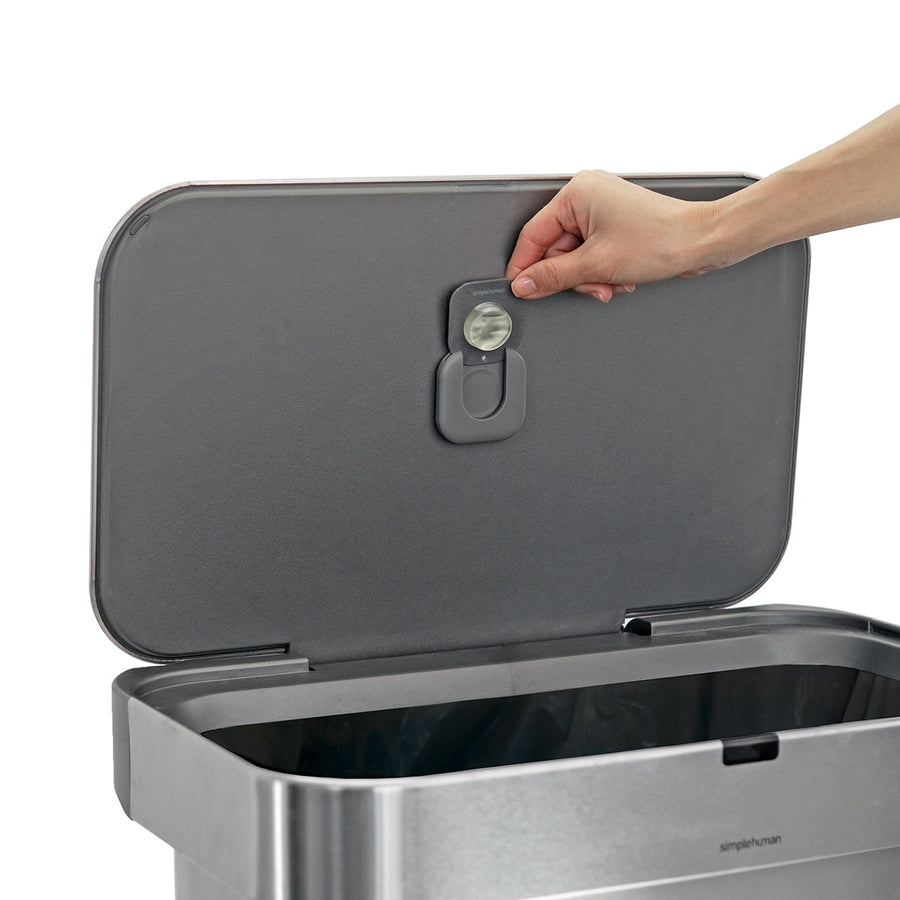 Usage view of Simplehuman Odorsorb Pod Dispenser on a trash can lid, demonstrating removal of the odor-absorbing refill pod.