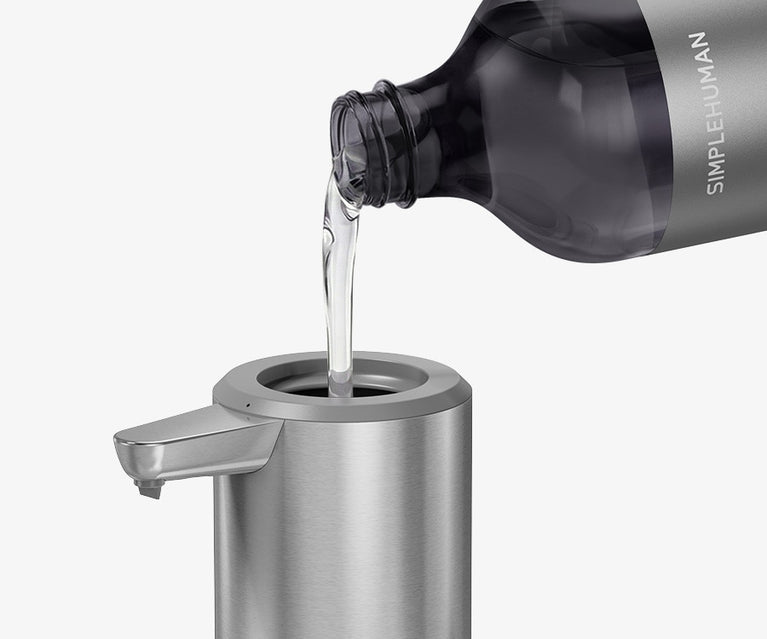 Simplehuman's Sensor Pump with a Simplehuman Refill Bottle pouring soap into the pump. 